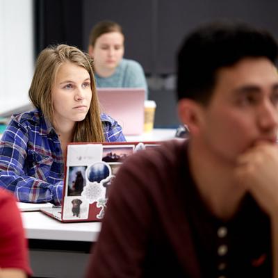 Three students in class listening to lecture
